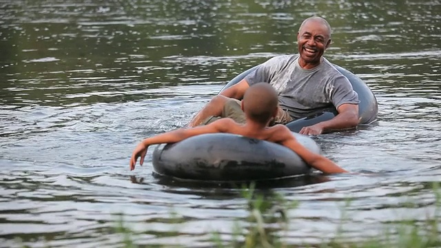 WS PAN TU的祖父和孙子(8-9)在美国弗吉尼亚州里士满河上互相泼水视频素材