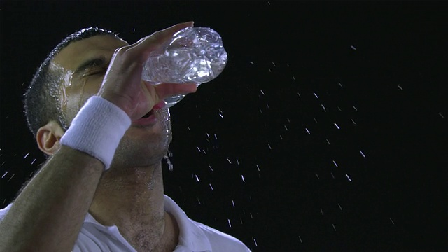 CU SLO MO网球运动员从水瓶里喝水，然后倒在头上/德国柏林视频下载