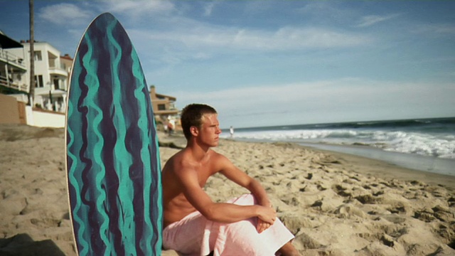 十几岁的男孩坐在海滩冲浪板，拉古纳海滩，美国加州视频素材