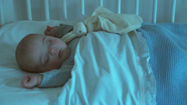 一名男婴(2-5个月)睡在比利时布鲁塞尔的婴儿床上视频素材