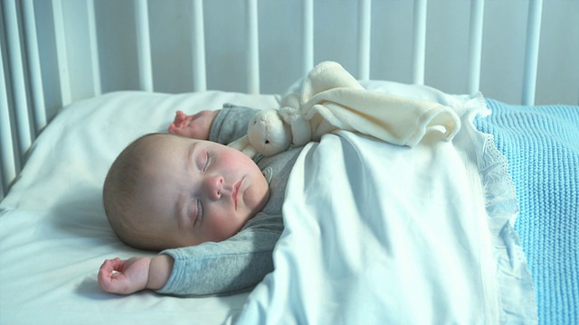 比利时布鲁塞尔，布拉班特，母亲看着婴儿(2-5个月)睡在婴儿床上视频素材
