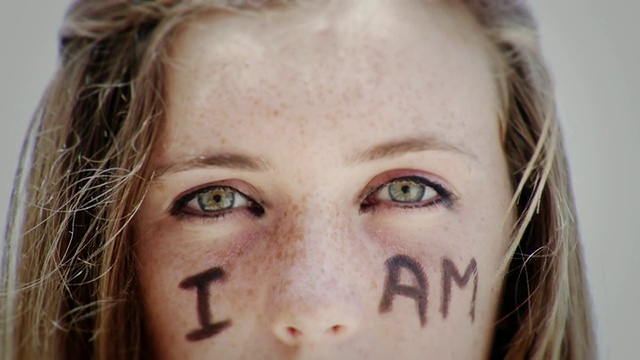 美国加州拉古纳海滩的少女肖像，脸上写着“我是”视频素材