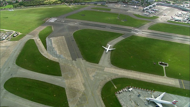 空中媒体拍摄英国航空公司飞机在希思罗机场跑道上滑行/缩小宽镜头拍摄飞机滑行/英国伦敦视频下载