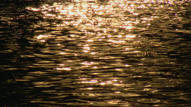 CU HA R/F在中国北京的后海，夕阳下的橙色阳光在水面上闪烁和反射视频下载