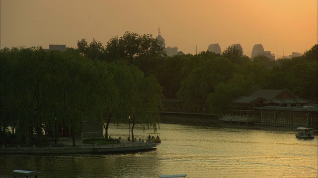中国北京，日落时分，人们在后海湖中划船视频下载