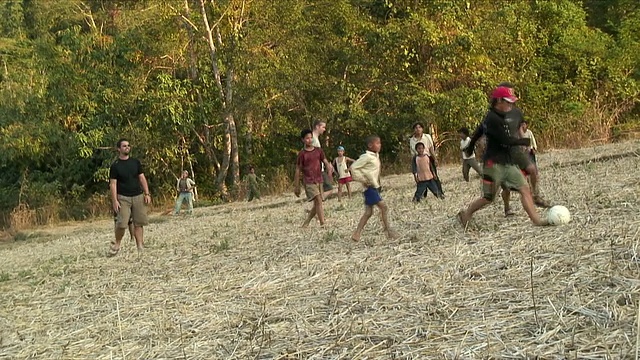 WS男孩在操场上踢足球，Pak Ou村庄，老挝视频素材