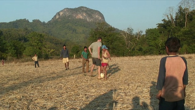 老挝北瓯村，男孩们在操场上踢足球视频素材