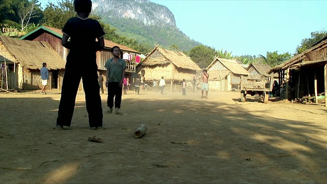 WS ZO男孩在村庄踢足球，Pak Ou村庄，老挝视频素材