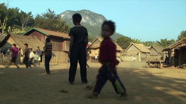 WS ZO男孩在村庄踢足球，Pak Ou村庄，老挝视频素材