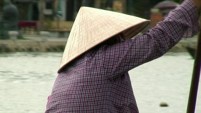 越南会安，一名戴着圆锥形帽子的女子在水中划船视频下载