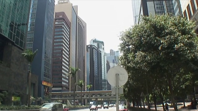 中国香港，市中心的交通和阳光反射在摩天大楼上视频下载