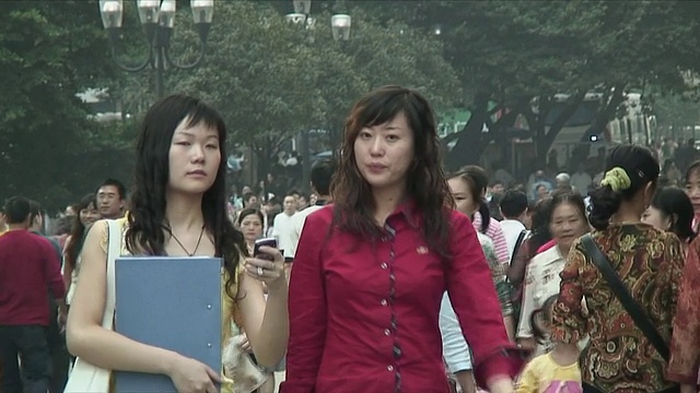 两名年轻女子在拥挤的人行道上，重庆，中国视频素材