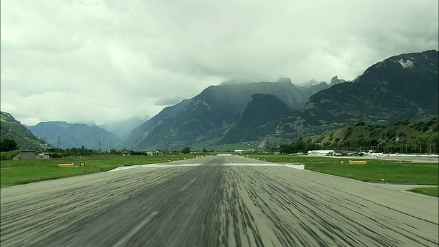 飞机从锡安机场起飞，背景是浓雾笼罩的山脉，瑞士瓦莱视频下载