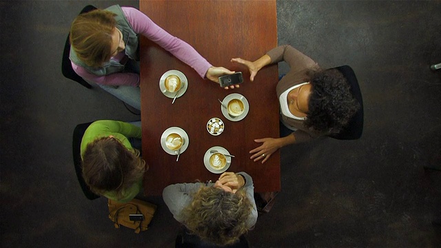 四个女人在喝咖啡，一个在打手机/南非西开普敦视频素材