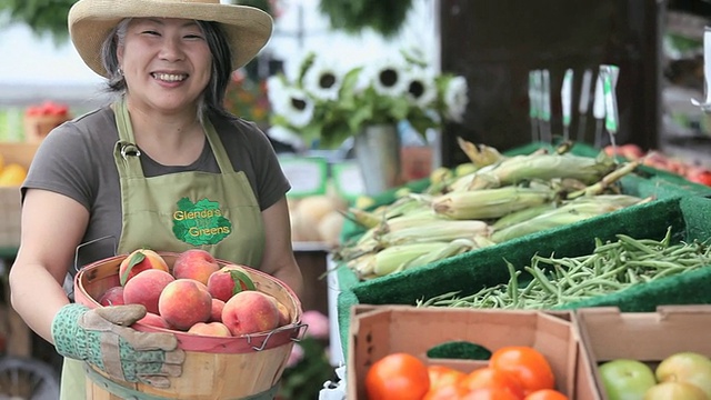 美国弗吉尼亚州里士满的农贸市场，一名小贩拿着一篮桃子视频素材