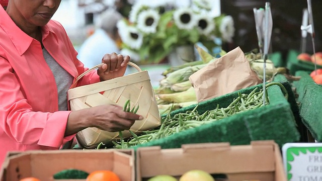 在美国弗吉尼亚州里士满农贸市场选购菜豆的女子视频素材