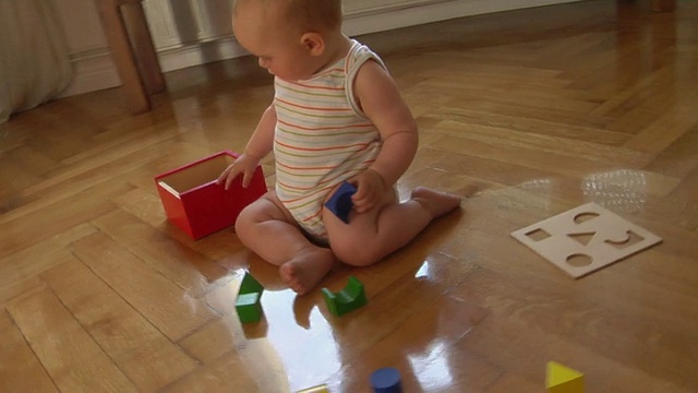 MS HA PAN女婴(6-11个月)坐在地板上玩积木，德国柏林视频素材