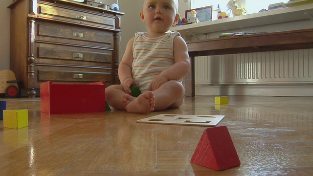 小女孩(6-11个月)坐在地板上玩积木，德国柏林视频素材