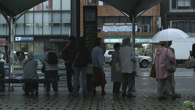 日本京都，在雨中的公交车站上的人们视频素材