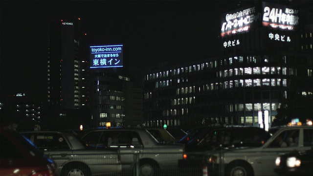 日本大阪，夜间交通繁忙，背景是办公大楼视频素材