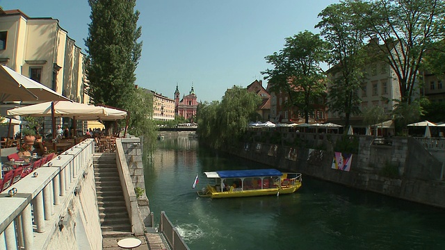 斯洛文尼亚，卢布尔雅那，在卢布尔雅那河上的WS HA游船，背景是德沃尔尼和方济各会报喜教堂视频素材