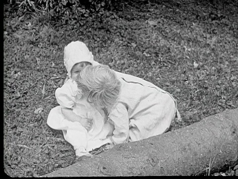 美国宾夕法尼亚州，一名男婴坐在草地上亲吻女婴视频下载