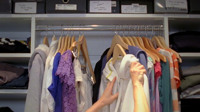 美国纽约，一名女子伸手在衣柜里挑衣服视频下载