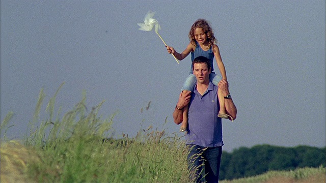 父亲肩上扛着女儿(6-7岁)，女孩手持风车/比利时布拉班特布鲁塞尔视频下载