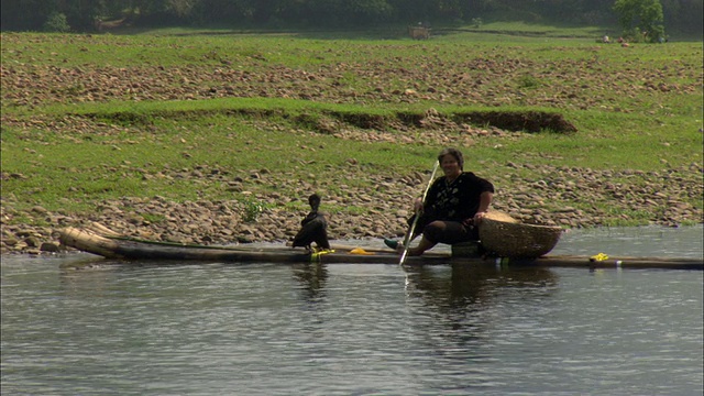 在广西壮族自治区桂林漓江上划着小船的女子视频素材