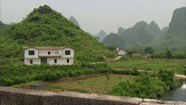 白色的房子和绿色的山，桂林，广西壮族自治区，中国的乡村景色视频下载