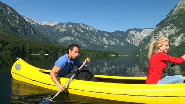 一对夫妇在湖上划独木舟视频素材