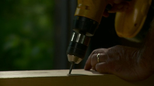 美国佛蒙特州斯托市，男子用电钻从木板上取下螺钉视频素材
