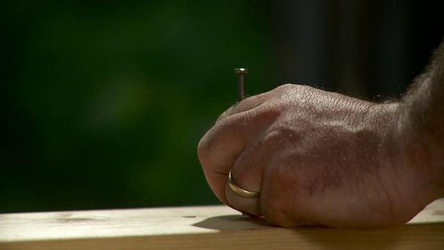 美国佛蒙特州斯托，一名男子将钉子钉进木板视频素材