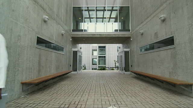 加拿大不列颠哥伦比亚省斯阔米什，穿着实验室大褂的男子走出大楼，正在打电话视频素材