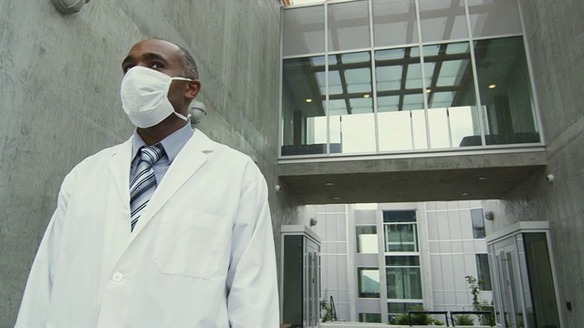 加拿大不列颠哥伦比亚省斯阔米什，身穿实验服、戴着流感口罩的LA人站在大楼外视频素材