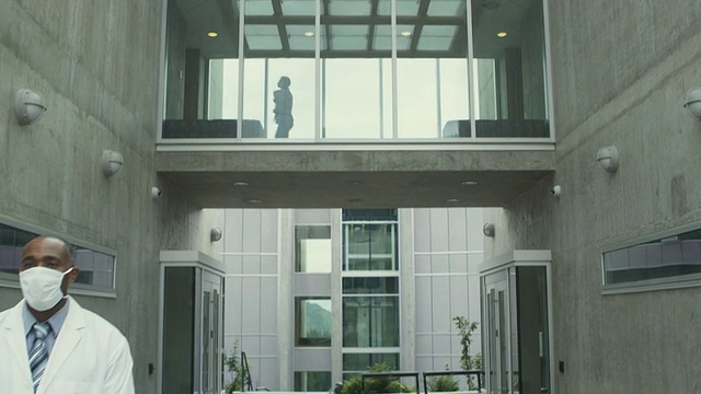 加拿大不列颠哥伦比亚省斯阔米什，一名身穿实验服、头戴流感口罩的男子站在大楼外视频素材
