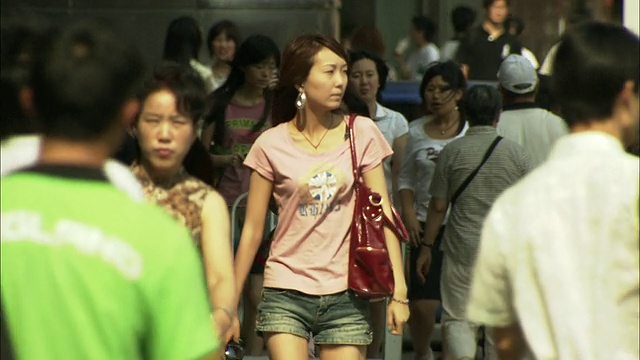 年轻女子在繁忙的西单购物区人行道上，北京，中国视频素材