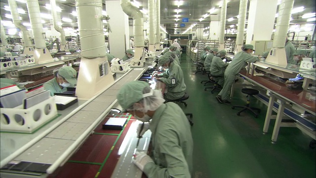 中国江苏无锡，Suntech Power Holdings工厂，一排排工人在太阳能电池板上工作视频下载