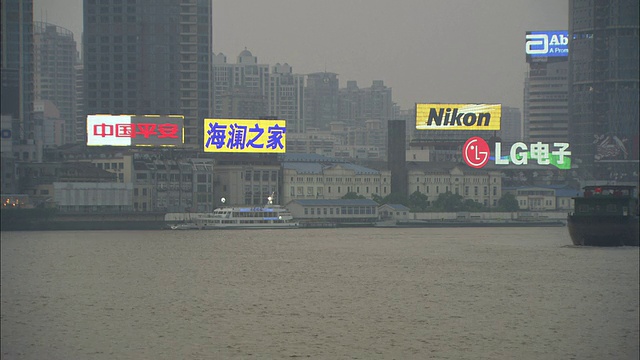 黄浦江上的WS PAN驳船和建筑物上的霓虹灯照明标志，上海，中国视频下载