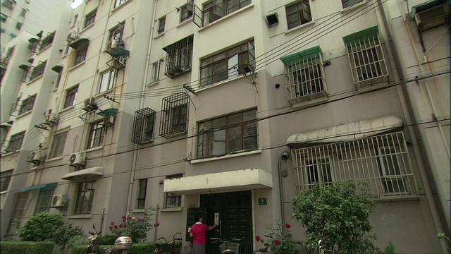 中国上海，一名女子走近公寓楼，按响了门铃视频下载