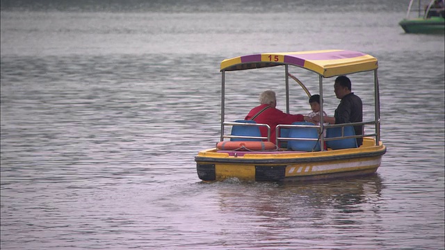 中国北京，父亲带着孩子和祖父母坐在后海湖中的小船上视频下载