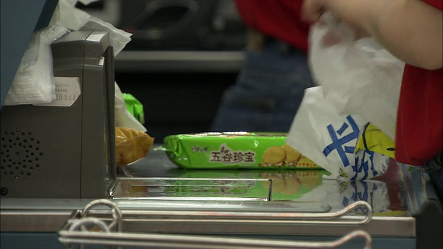 中国北京，在超市收银台包装购物的人视频素材