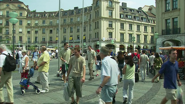 在德国巴伐利亚州慕尼黑，乘坐自动扶梯进入繁忙的城市广场视频素材