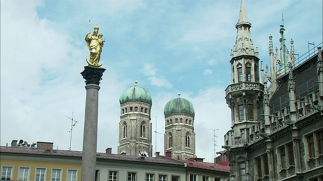 德国巴伐利亚州慕尼黑玛丽广场，MS市政厅塔和圣母教堂塔为背景的圣玛丽圆柱视频素材
