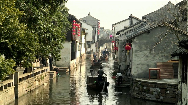 中国上海，人们在船里沿着建筑物之间的运河移动视频下载