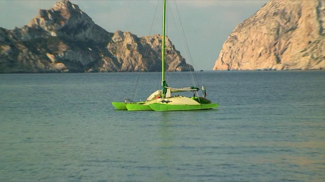 双体船系泊在岩石岛，Es Vedra，伊比沙，巴利阿里群岛，西班牙视频下载