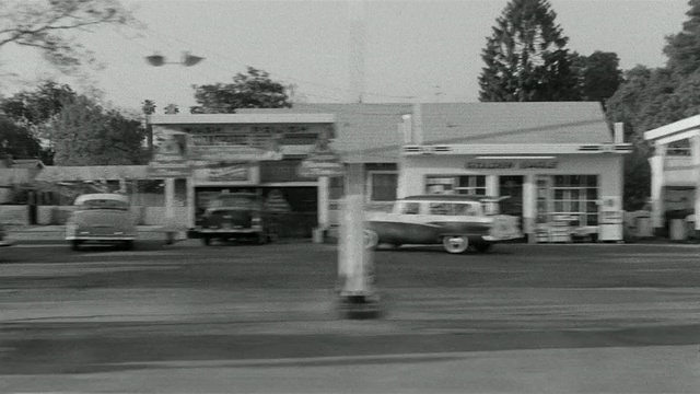 1955年，一辆汽车穿过南加州东加维大道的小型商业区视频素材