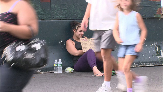 WS年轻无家可归的女人坐在人行道上举着要钱的牌子/纽约，纽约，美国视频下载