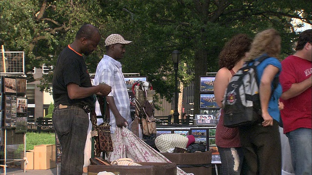 美国纽约，炮台公园，游客在购买包并与小贩交谈视频下载