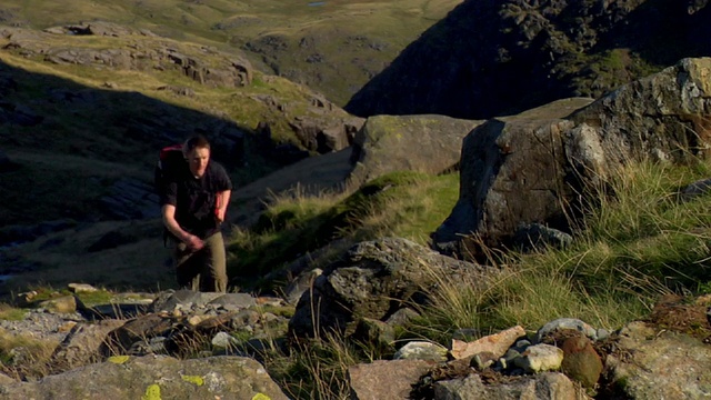 英国坎布里亚郡，一名年轻人正走在山间小路上视频素材